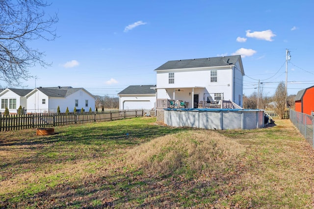 back of house with a lawn, a fenced backyard, and a fenced in pool