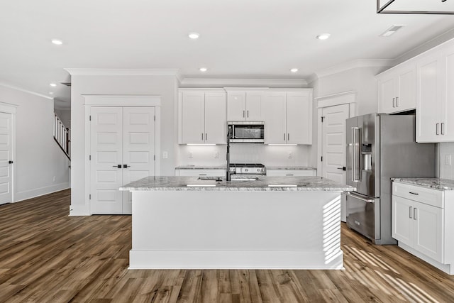 kitchen featuring appliances with stainless steel finishes, white cabinets, and a kitchen island with sink