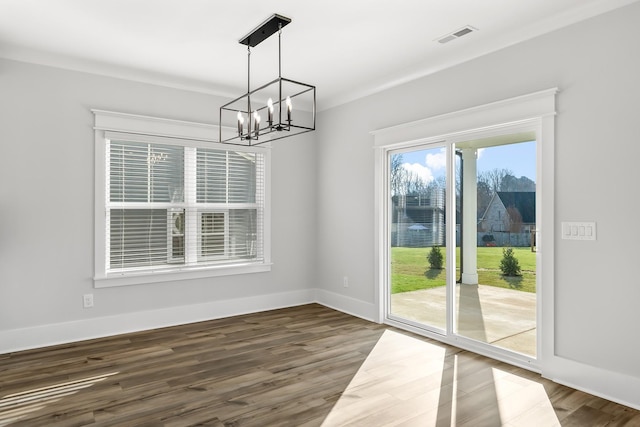 unfurnished dining area with a chandelier, dark wood-style flooring, visible vents, and baseboards