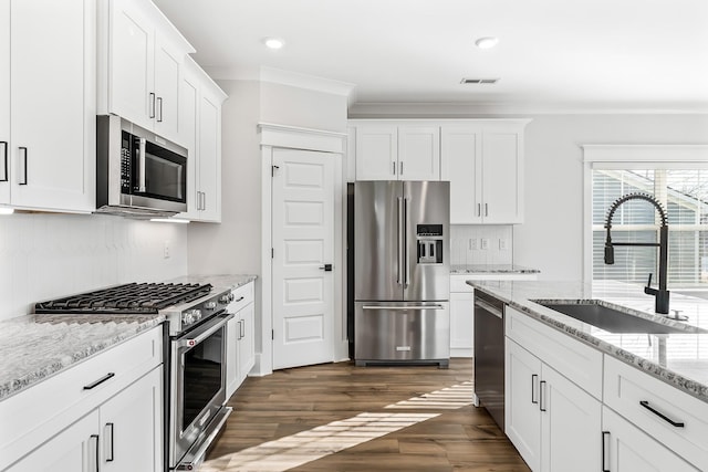 kitchen with a sink, visible vents, white cabinetry, and premium appliances