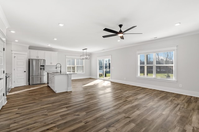 kitchen with pendant lighting, a kitchen island with sink, white cabinets, a sink, and high end refrigerator