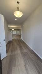 corridor with dark wood finished floors and baseboards