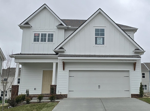 view of front of property with board and batten siding, concrete driveway, roof with shingles, and an attached garage