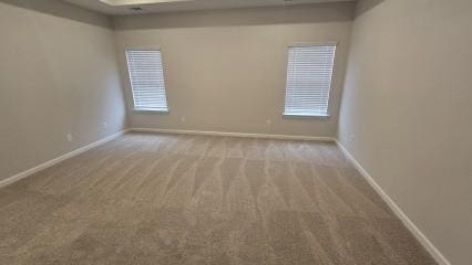 unfurnished room with baseboards and light colored carpet