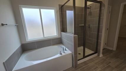 full bath featuring a stall shower and a garden tub