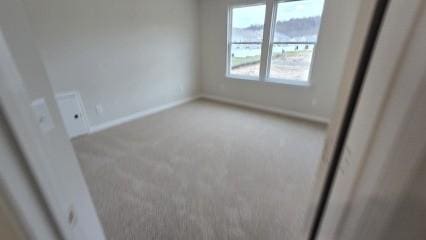 unfurnished room with carpet floors and baseboards