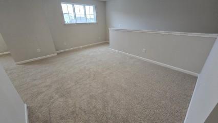 spare room with light colored carpet and baseboards