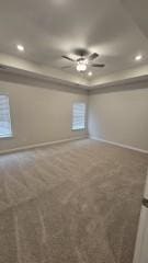 carpeted spare room featuring ceiling fan, baseboards, a raised ceiling, and recessed lighting