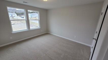 carpeted spare room featuring baseboards