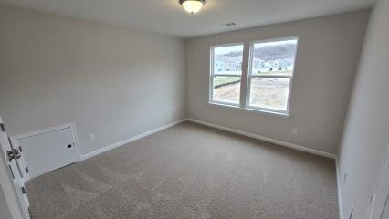 carpeted spare room featuring baseboards