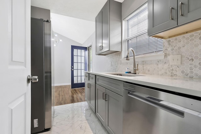 kitchen featuring light countertops, appliances with stainless steel finishes, gray cabinets, and a sink