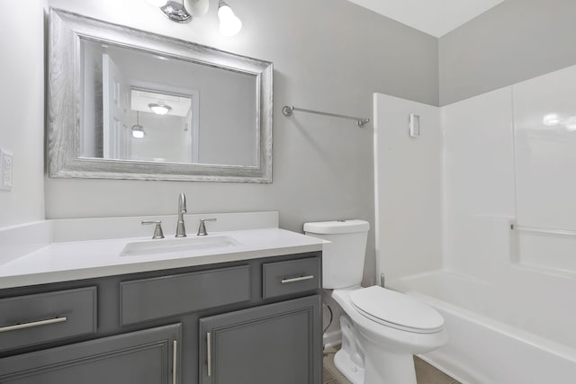 full bathroom featuring washtub / shower combination, vanity, and toilet