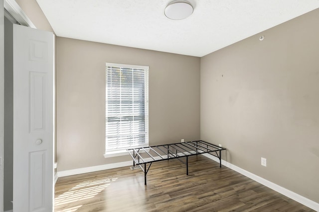 interior space featuring dark wood-type flooring, a wealth of natural light, and baseboards