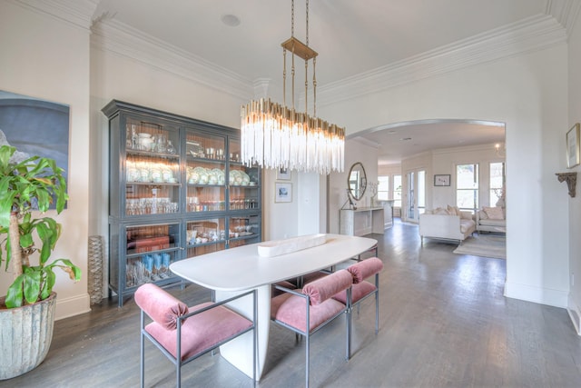 dining room featuring baseboards, arched walkways, dark wood-type flooring, and ornamental molding