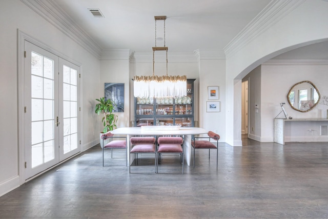 dining room featuring arched walkways, dark wood-style flooring, visible vents, and french doors