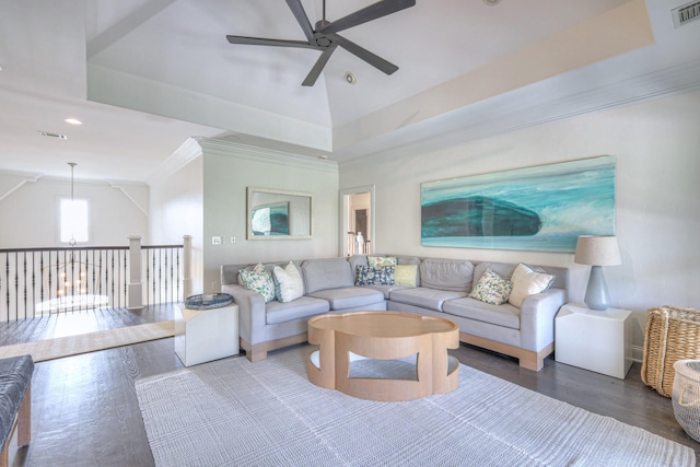 living room featuring a ceiling fan, a raised ceiling, and wood finished floors