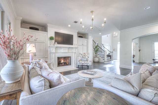 living room with stairs, ornamental molding, arched walkways, and a fireplace with flush hearth