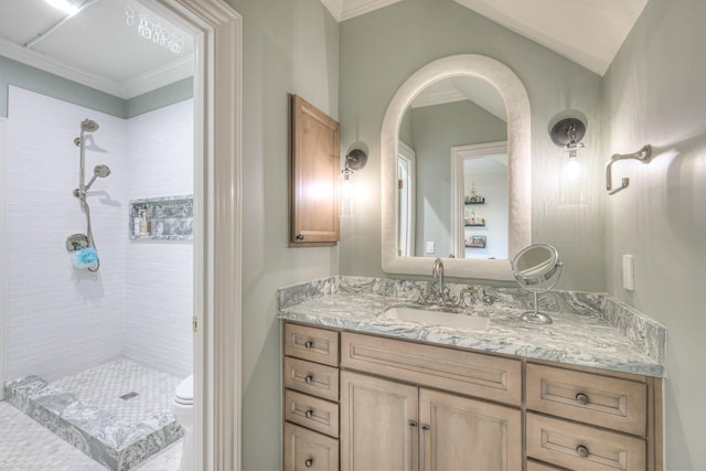 bathroom featuring tiled shower, crown molding, vanity, and toilet