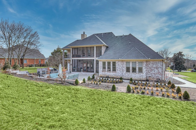 rear view of property with a yard, a sunroom, a patio, and a chimney