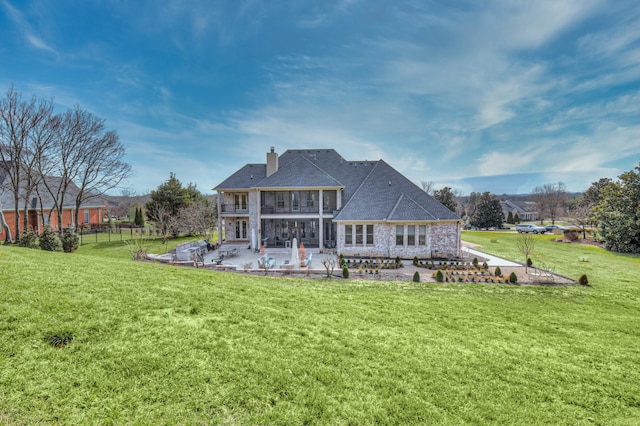 rear view of house featuring fence, a patio, a chimney, and a lawn