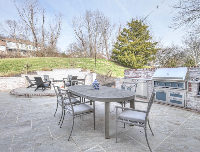 view of patio with outdoor dining space, exterior kitchen, and area for grilling