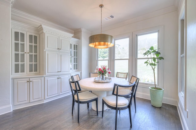 dining area with ornamental molding, dark wood finished floors, visible vents, and baseboards