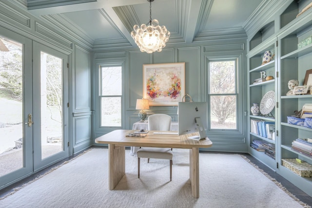 office featuring a notable chandelier, a decorative wall, coffered ceiling, french doors, and ornamental molding