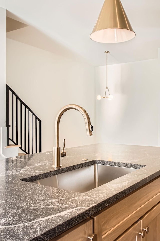 605A Morrow Rd, Nashville, TN 37209 - details featuring brown cabinetry, pendant lighting, a sink, and dark stone countertops