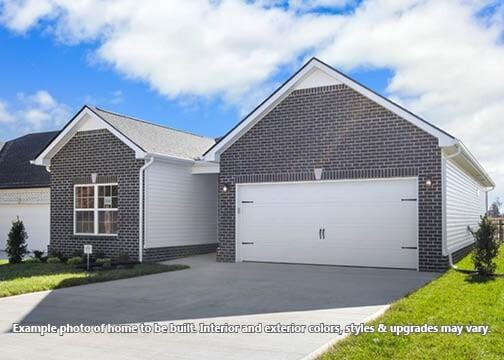 ranch-style house featuring brick siding, driveway, and an attached garage