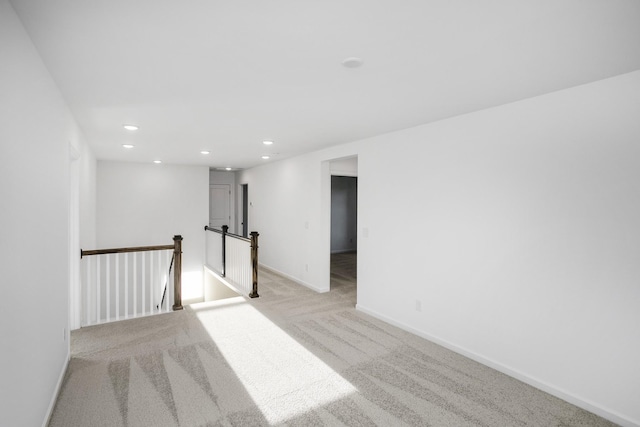 unfurnished room with light carpet, baseboards, and recessed lighting