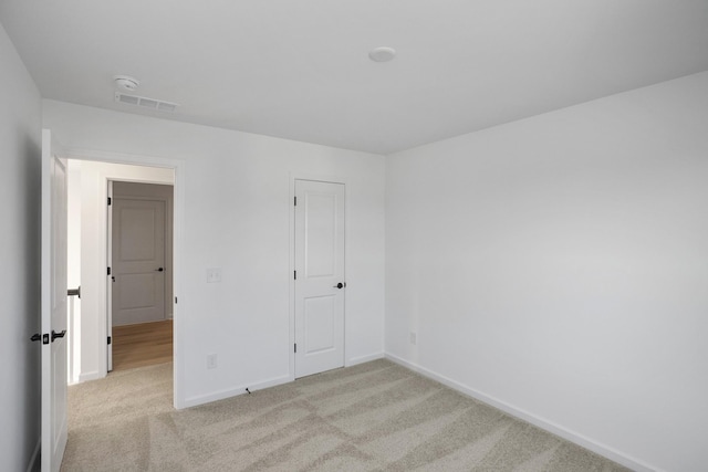 unfurnished bedroom featuring light carpet, baseboards, and visible vents