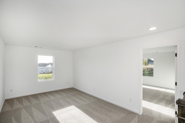 unfurnished room featuring baseboards, recessed lighting, and light colored carpet