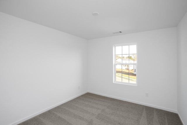 carpeted spare room with visible vents and baseboards