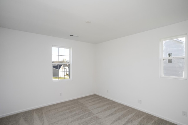 empty room with light colored carpet and baseboards