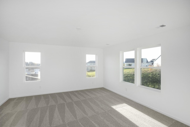 unfurnished room with light carpet and baseboards