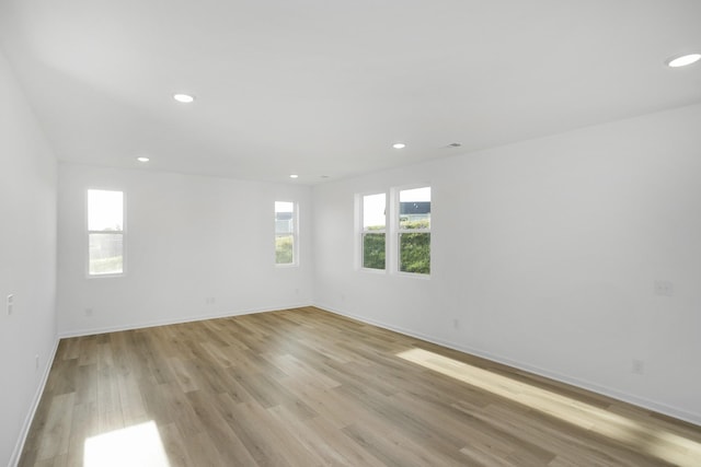 spare room with light wood-type flooring, baseboards, and recessed lighting