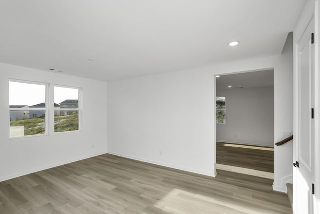 empty room with recessed lighting, light wood-type flooring, visible vents, and baseboards