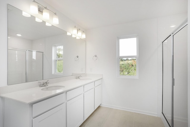 bathroom featuring a shower stall, a sink, and a healthy amount of sunlight