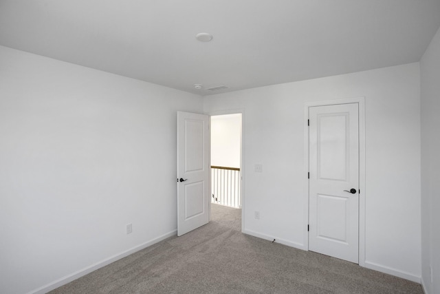 unfurnished bedroom with light carpet, visible vents, and baseboards