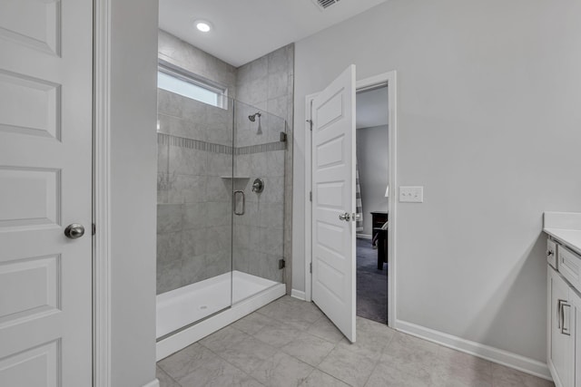 bathroom featuring visible vents, a shower stall, baseboards, and vanity