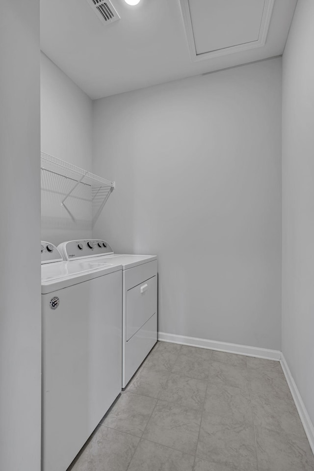 clothes washing area featuring laundry area, visible vents, washer and clothes dryer, and baseboards