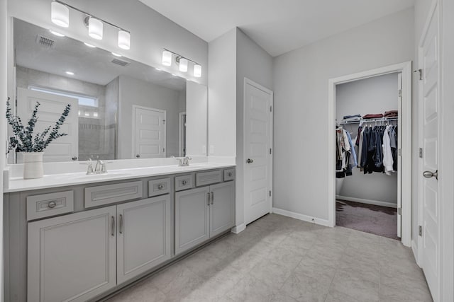 bathroom with a sink, visible vents, baseboards, a shower stall, and double vanity