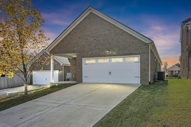 view of front of home with central air condition unit, a garage, brick siding, driveway, and a front yard