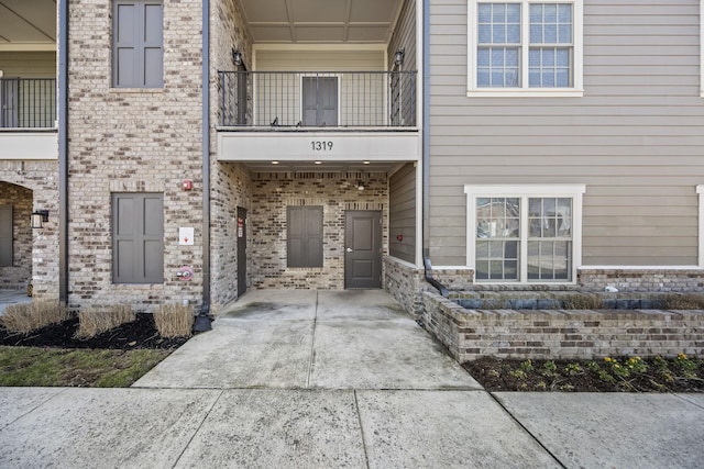 exterior space featuring a carport, brick siding, and driveway