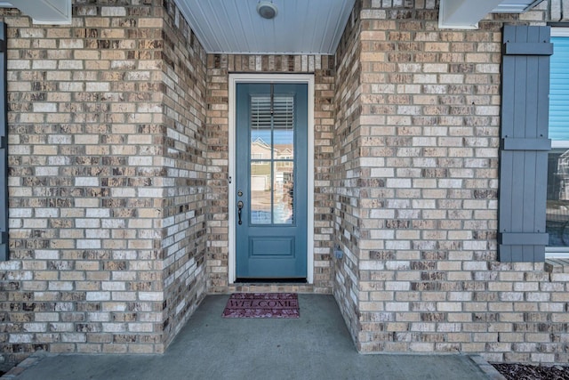 property entrance featuring brick siding