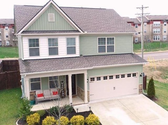 view of front facade with an attached garage, driveway, a front lawn, and board and batten siding