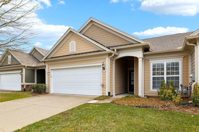 view of front of house featuring a shingled roof, a front yard, driveway, and an attached garage