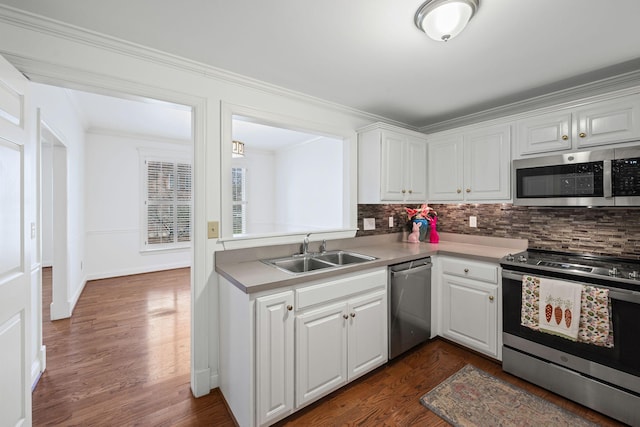 kitchen featuring appliances with stainless steel finishes, white cabinets, and a sink