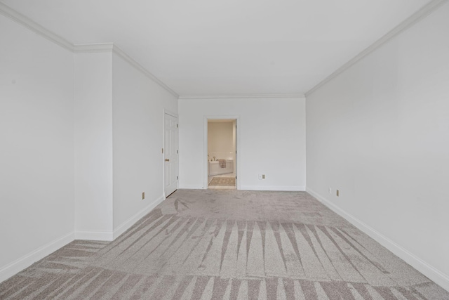 unfurnished room with light colored carpet, crown molding, and baseboards