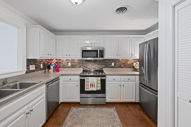 kitchen with stainless steel appliances, light countertops, white cabinetry, and visible vents